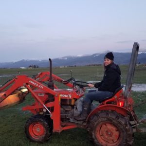 Farm working sitting on a orange kutoba tractor